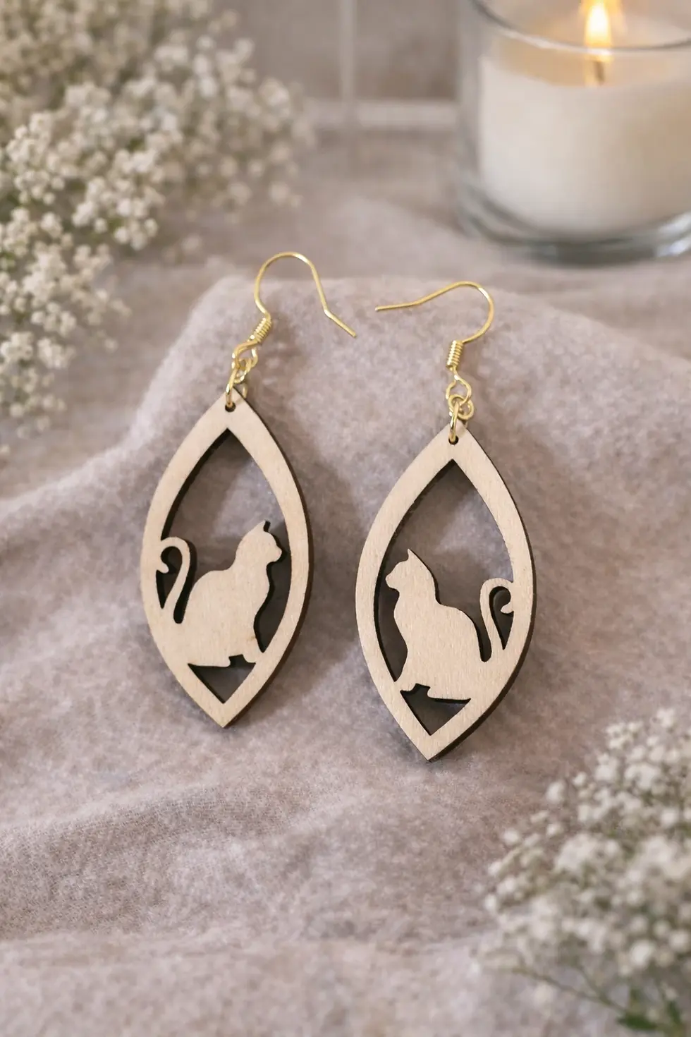 Boucles d'oreilles pendantes en bois avec silhouette de chat découpée.
