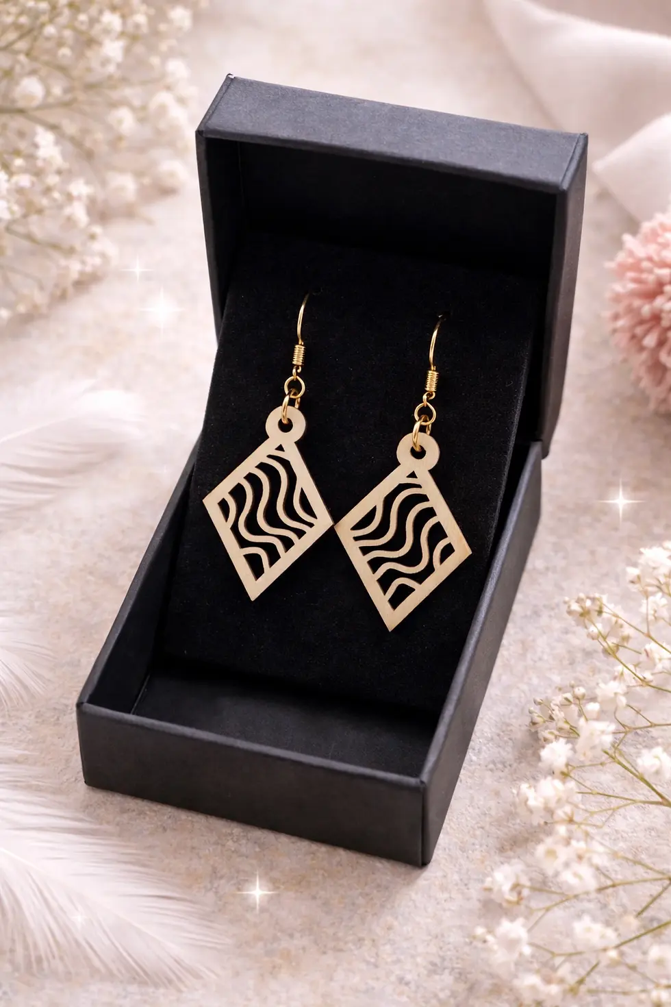 Paire de boucles d'oreilles en bois, losange ajouré, motif ondulé dans écrin noir.