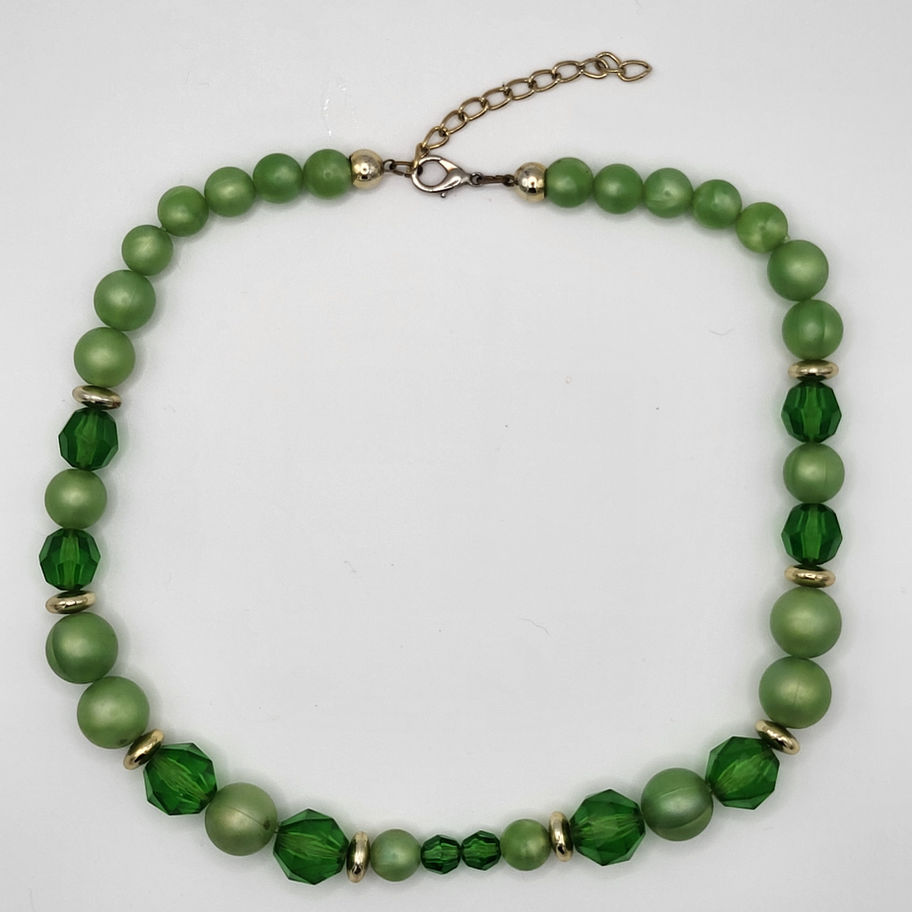 Collier de perles vertes, nuances claires et foncées, avec perles dorées.