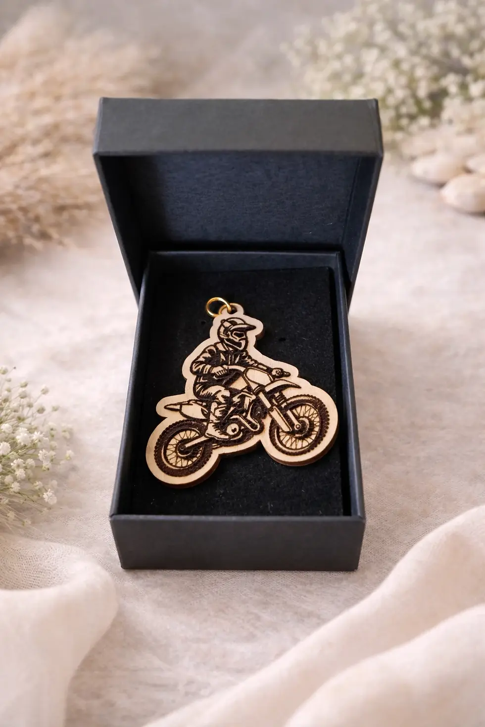 Porte-clés moto tout-terrain en bois dans boîte cadeau noire ouverte.