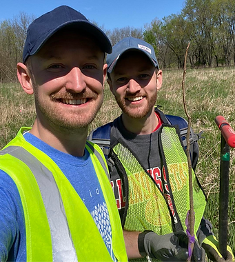 Photo of Cody Hendricks and husband Eric Hansen participating in a neighborhood cleanup on Earth Day 2023.