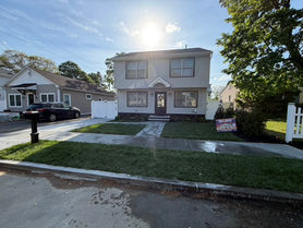 Two-story colonial exterior with new walkway and landscaping renovated by Sevens Services in New Jersey
