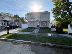 Two-story colonial exterior with a new walkway and landscaping in New Jersey