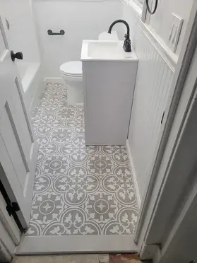 Patterned encaustic tile floor beside a new shower base in a New Jersey bathroom remodel
