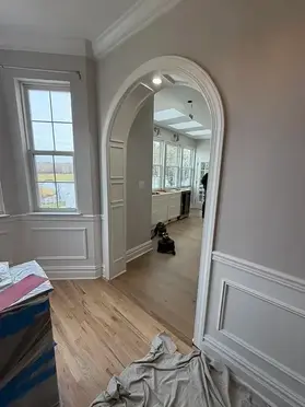 Entry hall with wainscoting and an arched opening from a New Jersey whole-home renovation