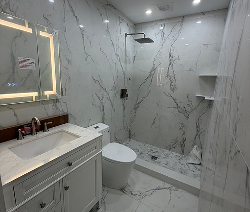 Porcelain marble shower with rainfall head and floating vanity from a Sevens Services bathroom build in New Jersey