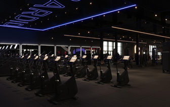 Rows of cardio bikes in a New Jersey gym, 'CARDIO' neon sign. | Alpha Gym Ocean Township