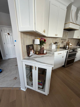 Kitchen with glass-front upper cabinets, quartz counters and a stainless range in New Jersey