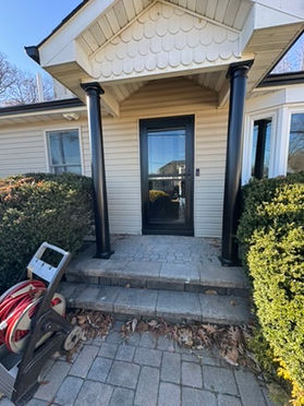 Front entry porch with black columns and a new steel door in New Jersey
