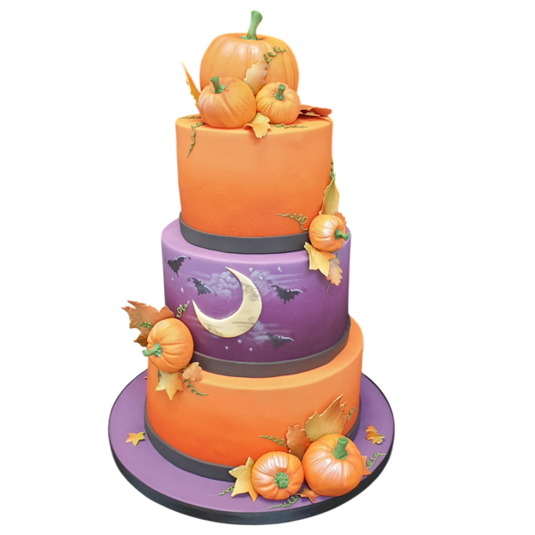 Three-tier wedding cake with pumpkins, crescent moon, bats, and autumnal decorations.