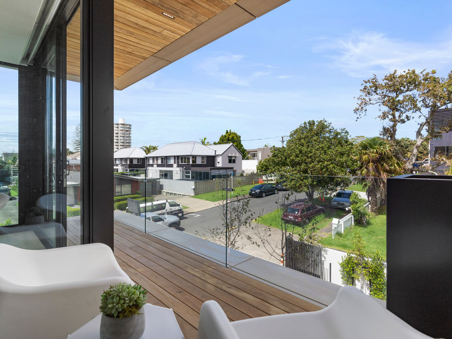 Modern balcony overlooking a quiet residential street with cars and trees
