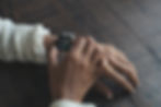 Close up of a person's hands, checking their watch on their left wrist