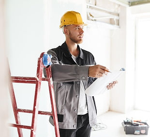 young-engineer-work-clothes-yellow-hardhat-dreamily-looking-aside-holding-plan-new-apartme