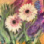 Two gerber blooms sway amidst the surrounding garden