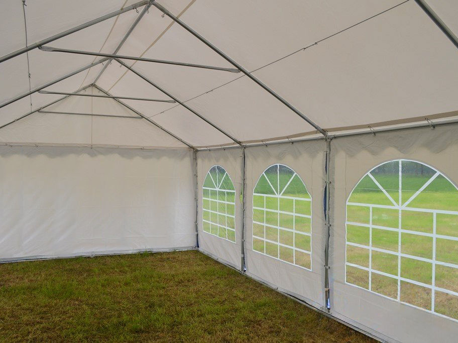 Binnenzijde van een witte partytent met boogvensters.