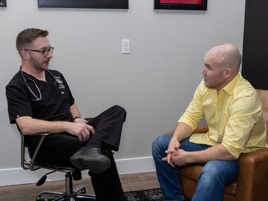 A healthcare provider and patient engaged in a one-on-one consultation in a clinic setting.