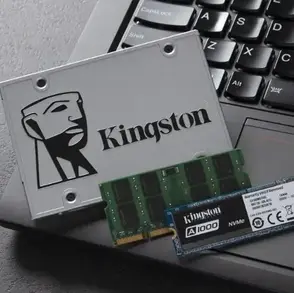 Laptop deschis cu componente RAM si SSD pregatite pentru instalare, solutie ideala pentru cresterea performantelor.