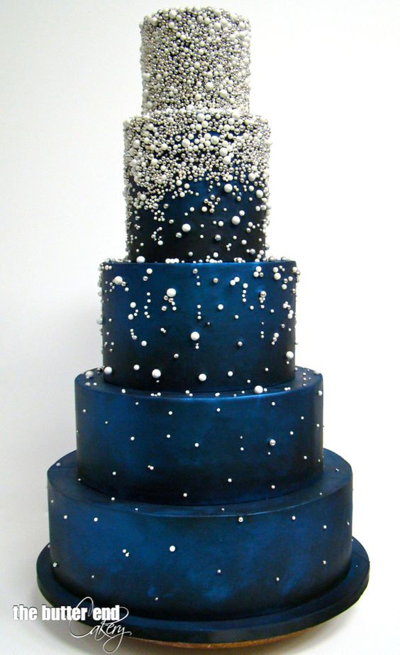 Tiered wedding cake in celestial dark blue encrusted with edible pearls and beads by The Butter End Cakery.