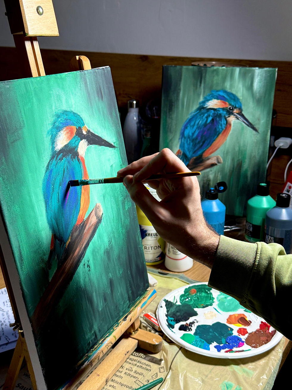 Ein Mann malt einen Eisvogel bei einem Malkurs