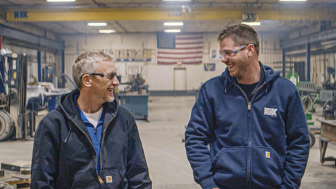 two people walking through metal fabrication shop
