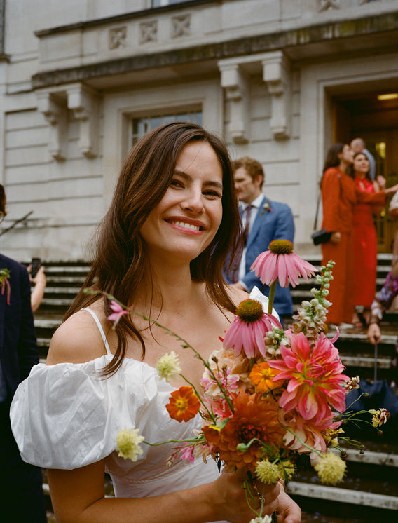 Becky and her mid summer bridal bouquet of local flowers outside hackney town hall 