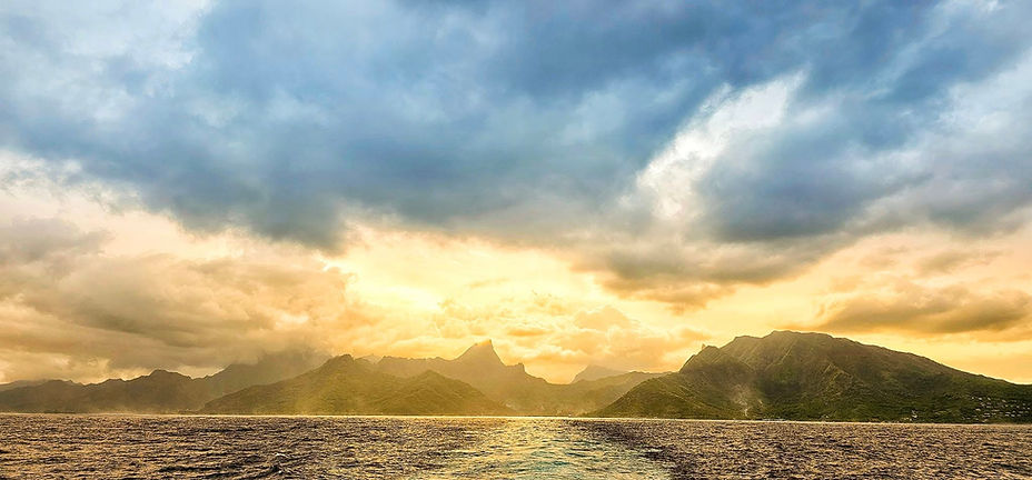 Mo’orea island at sunrise, bathed in golden morning light, photographed from the ferry at the close of our humpback whale retreat in French Polynesia — a farewell moment of gratitude, integration, and deep connection with this sacred island.