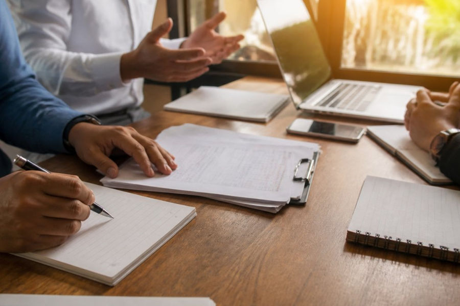 Equipo de TI y consultores revisan el cronograma para implementar ISO 27001 en una oficina corporativa.