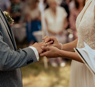 Braut steckt dem Bräutigam Ring an