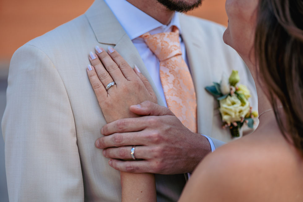 Hände mit Eheringen, Jasmin & Oliver, zärtlich aneinander auf einer Hochzeit