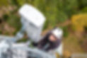 man at top of tower posing for photo while installing wireless equipment