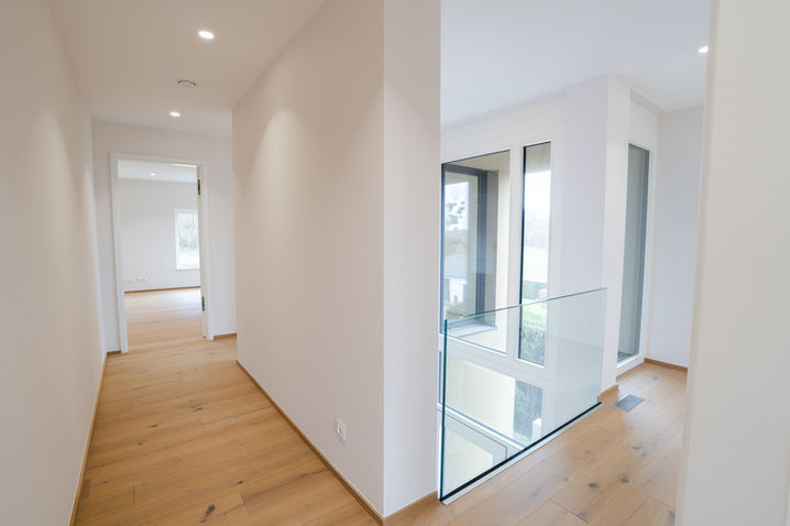 Bright hallway with wooden flooring and clean white walls, real estate photography Luxembourg