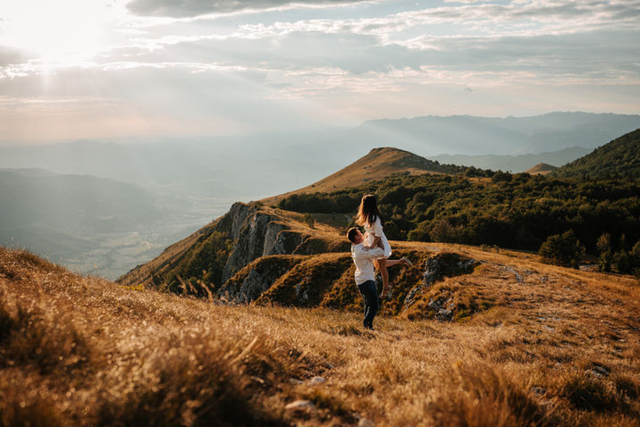 Romantic couple embracing on a hill at golden hour sunset in Mullerthal, Luxembourg.