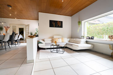 A relaxed living room area in Luxembourg, with a huge sofa and a large window on the side.
