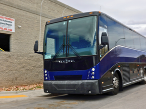 Van Hool commercial shuttle bus parked outside Cruz Auto & Fleet Services in Las Vegas, NV for fleet maintenance and commercial vehicle repair service.
