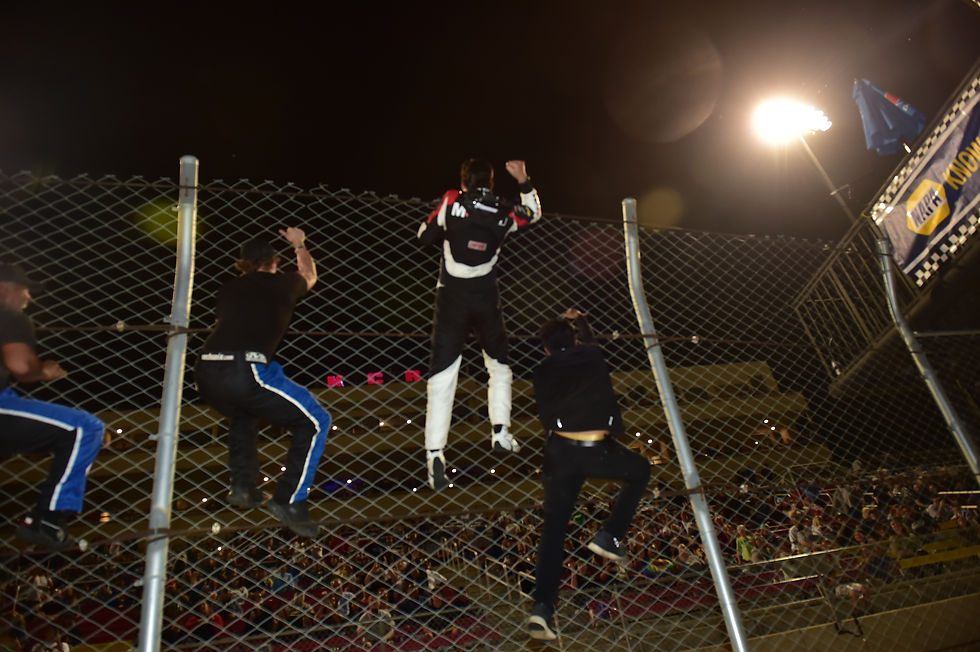 Sean climbs the fence after winning at Kern