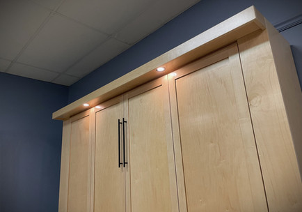 Murphy bed lights and face in a natural maple finish. 