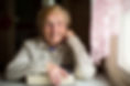 old woman sitting by a window holding a book-shutterstock_363299828-2048.jpeg