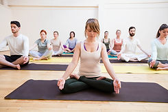 trainer-assisting-group-people-with-lotus-position.jpg