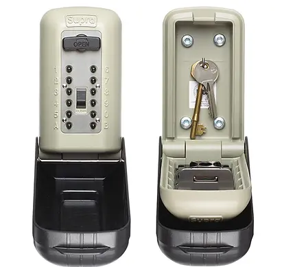 A beige and black Supra key lock box with a mechanical push-button keypad. The image shows two views: one with the box closed displaying the keypad, and one with the box open revealing keys stored inside and mounted on a hook.