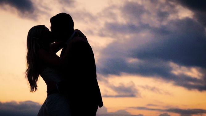 Bride and groom share a warm embrace during magic hour on their wedding day. Wedding photo captured by 4Everscope Media.