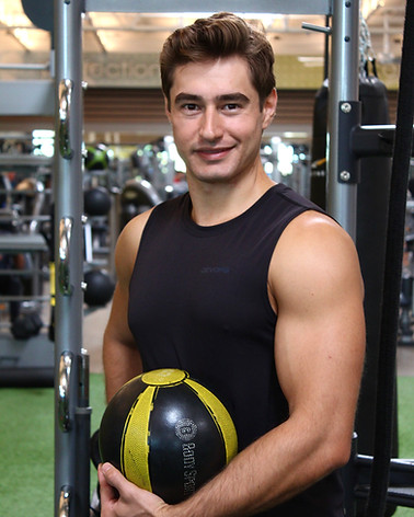 Personal trainer George Kostopoulos holding a medicine ball in the gym