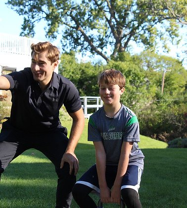 George Kostopoulos encouraging a smiling young client during a backyard workout