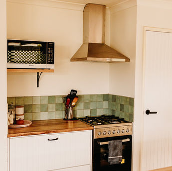 Gumnut cottage kitchen, showing oven, stovetop, microwave and large drawers.