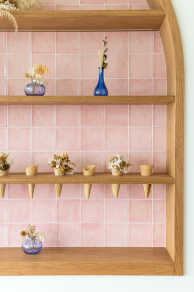 Revêtement mural rose brillant évoquant les teintes des glaces – ambiance colorée et joyeuse du glacier Café NOMY.