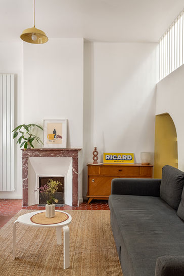 Salon lumineux avec cheminée conservée et tommettes d’origine – rénovation d’une maison individuelle à Marseille par Violaine Planchard Architecture.