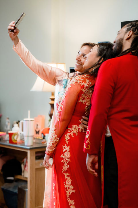 A family dressed in traditional Vietnamese outfits taking a selfie at a home in Connecticut.