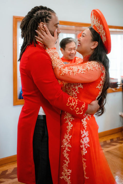 Bride and groom smiling at each other after a vietnamese tea ceremony in Connecticut.