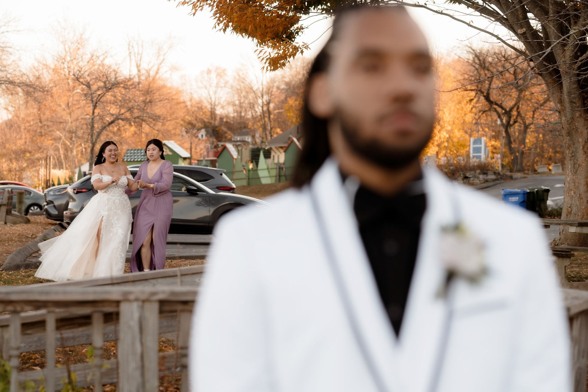 A bride walking up behind a groom outside of The Lace Factory in Connecticut.