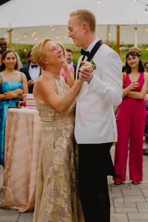 A groom dancing with his mother at wedding reception.