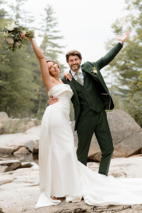 bride and groom celebrating on a rocky river in the White Mountains of New Hampshire